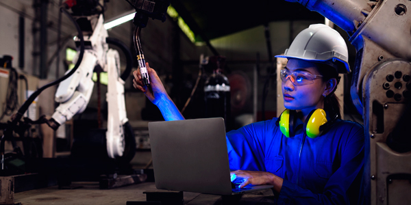 Woman operating computer and looking at handheld tools