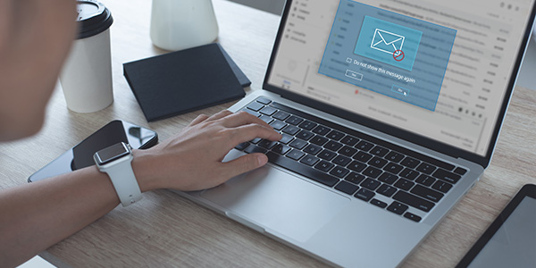 Person reviewing emails on laptop with pop up on screen saying do not show this message again