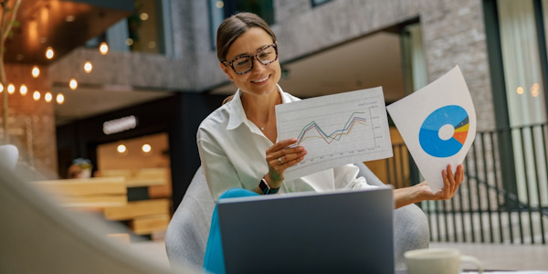 executive viewing her company's financial reports with a smile on her face