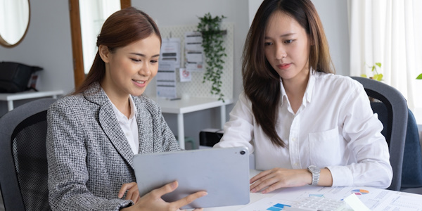 Two business women learning about business emergency funds